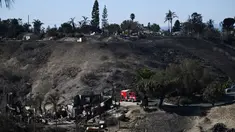 Petugas pemadam kebakaran mencari sisa titik api di lingkungan perumahan yang hancur akibat kebakaran hutan yang disebabkan oleh angin di Camarillo, California pada tanggal Jumat 8 November 2024. (Patrick T. Fallon/AFP)
