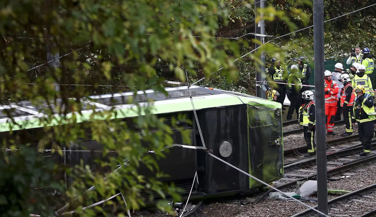 Petugas layanan darurat tiba di lokasi terbaliknya sebuah trem di sebuah terowongan di Croydon, London Selatan, Inggris, Rabu (9/11). Sebanyak tujuh orang tewas dan lebih dari 50 orang mengalami luka-luka akibat trem yang keluar jalur. (REUTERS/Neil Hall)