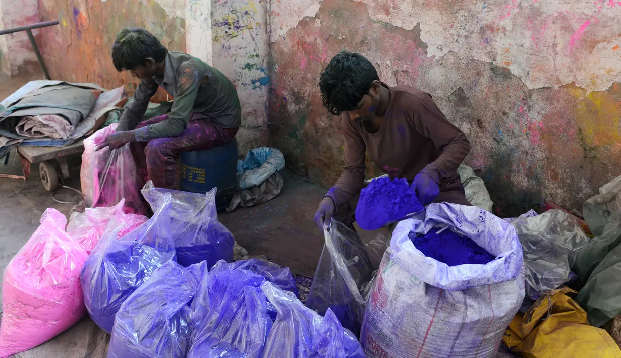 Pekerja mengemas bubuk warna herbal yang ramah lingkungan menjelang festival Holi di sebuah pabrik di pinggiran Ahmedabad, India (7/3). Warna herbal ramah lingkungan ini dibuat di pabrik Jerman Chemicals. (AFP Photo/ Sam Panthaky)