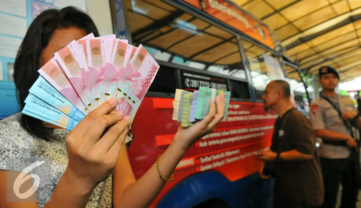 Seorang wanita menunjukan beberapa mata uang baru di Blok M, Jakarta, Senin (19/12). Bank Indonesia (BI) hari ini meluncurkan 11 uang rupiah Emisi 2016 dengan gambar pahlawan baru. (Liputan6.com/Angga Yuniar)