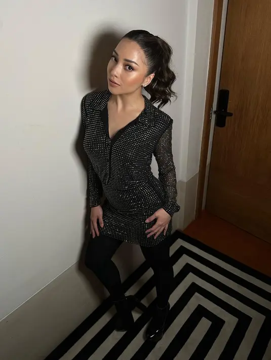 Di potret ini, Nikita Willy tampil ala party people dengan busana bling-bling. Ia mengenakan mini dress sequin hitam metalik dengan stocking hitam. [@nikitawillyofficial94]