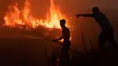 Seorang pemilik perkebunan cabai berusaha memadamkan kobaran api di lahan gambut untuk melindungi lahan miliknya di Ogan Ilir, Sumatra Selatan. Foto diambil pada tanggal 2 Oktober 2023. (Al ZULKIFLI/AFP)