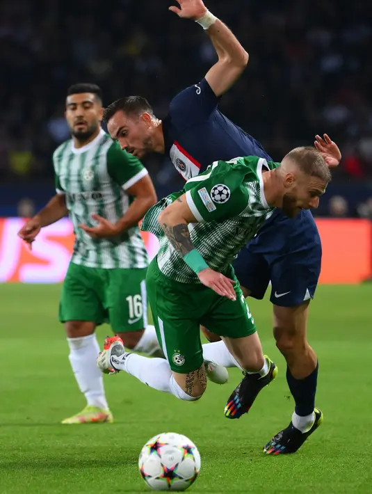 Pemain depan Paris Saint-Germain (PSG) Pablo Sarabia berebut bola dengan bek Maccabi Haifa Pierre Cornud pada matchday kelima Grup H Liga Champions 2022/23 di Parc des Princes, Rabu (26/10/2022) dinihari WIB. Sementara itu dua gol balasan Maccabi Haifa disumbangkan oleh Abdoulaye Seck di masing-masing babak. (Anne-Christine POUJOULAT / AFP)