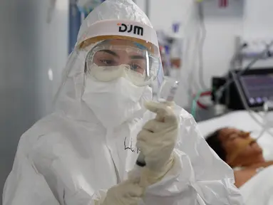 Seorang perawat menyiapkan suntikan untuk pasien COVID-19 di ICU Rumah Sakit Nasional di Itagua, Paraguay, Senin (7/9/2020).  (AP Photo/Jorge Saenz)