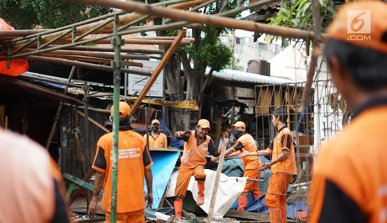 Petugas PPSU membongkar bangunan kios pedagang nasi kapau di Jalan Kramat Raya, Senen, Jakarta, Jumat (6/9/2019). Pembongkaran disebabkan adanya rencana revitalisasi trotoar di jalan tersebut. (Liputan6.com/Immanuel Antonius)