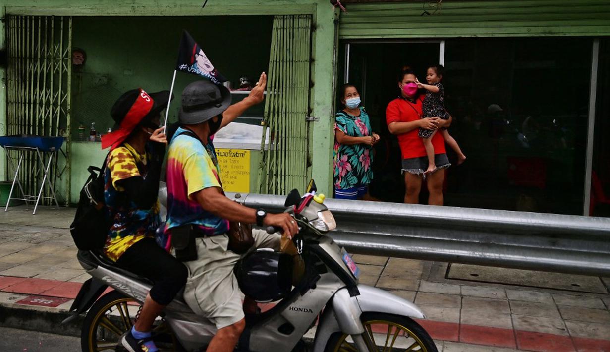 Demonstran menyapa warga saat melakukan konvoi dalam unjuk rasa di Bangkok, Thailand, Jumat (10/9/2021). Demonstran mendesak Perdana Menteri Thailand Prayut Chan-O-Cha mengundurkan diri atas penanganan pemerintah terhadap COVID-19 dan pembebasan tahanan politik. (LILLIAN SUWANRUMPHA/AFP)