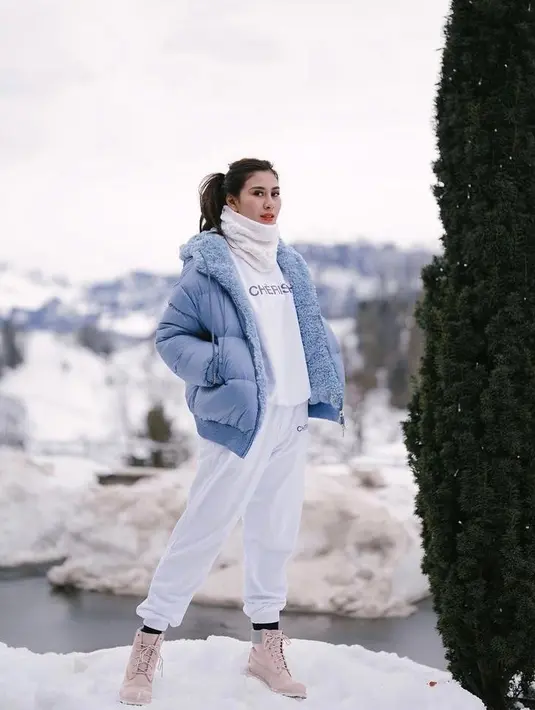 Berpose di tengah hamparan salju, Syahnas memadukan jaket tebalnya dengan sweater, jogger, dan syal serba putih. Kece ! (Instagram/syahnazs).