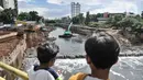 Warga melihat proyek pembangunan sodetan Kali Ciliwung di Banjir Kanal Timur (BKT), Jakarta Timur, Senin (20/2/2023). Progres pembangunan sodetan Kali Ciliwung menuju BKT sudah mencapai 62 persen. Proyek yang menelan biaya mencapai Rp1,2 triliun ini ditargetkan berfungsi paling lambat April 2023. (merdeka.com/Iqbal S Nugroho)