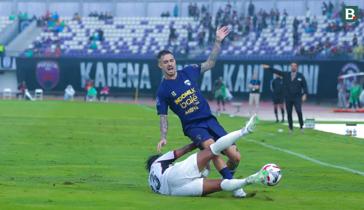 Pemain Persita Tangerang, Rayco Rodríguez, terjatuh saat berusaha melewati pemain Persik Kediri dalam laga lanjutan BRI Super League 2025/2026 di Stadion Indomilk Arena, Minggu (21/12/2025) sore WIB. (Bola.com/ M Iqbal Ichsan)