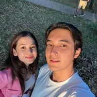 Sandrinna dan Julian Roberts sempat kompak mengenakan kaos putih. Bedanya, Sandrinna menambahkan outer pink untuk mempercantik penampilannya.[instagram/sandrinna_11]