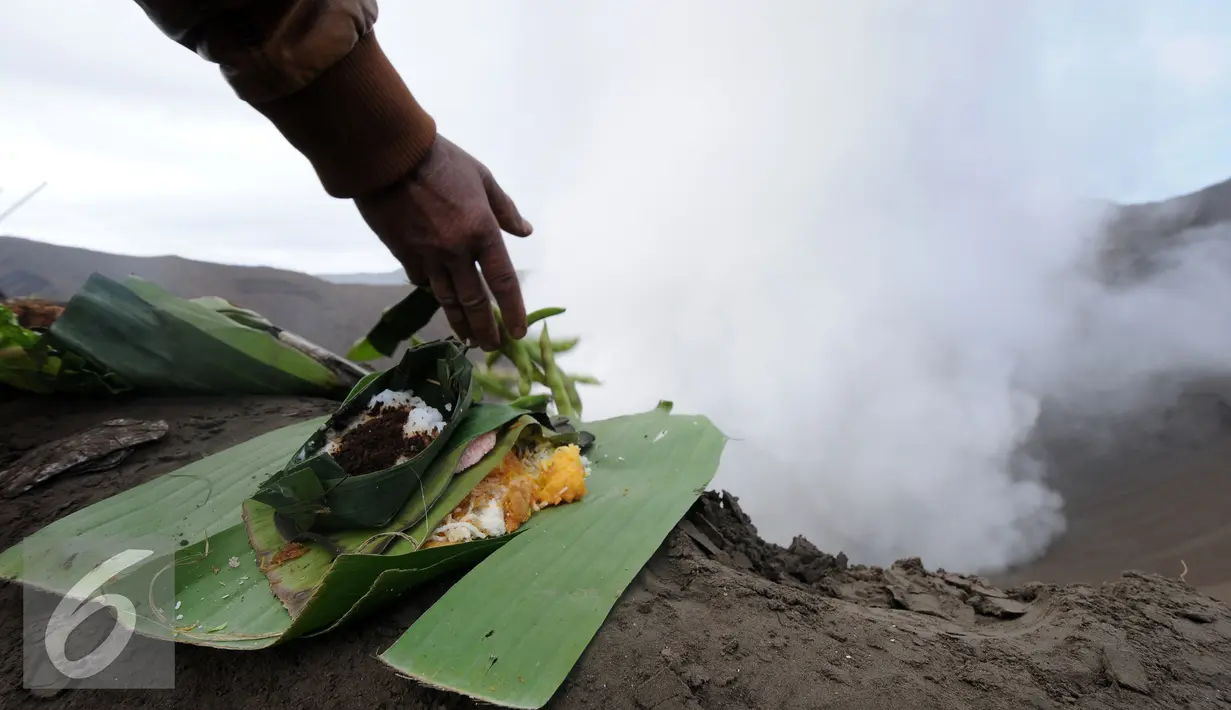 Warga suku Tengger meletakkan sesaji di bibir kawah Gunung Bromo saat Kasada, Probolinggo, Kamis (21/6). Meski Gunung Bromo mengalami erupsi, tidak menyurutkan niat warga untuk melempar sesaji ke kawah Bromo. (Liputan6.com/Helmi Fithriansyah)