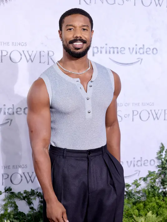 Michael B. Jordan berpose menghadiri pemutaran perdana "The Lord of the Rings: The Rings of Power" di The Culver Studios di Culver City, California (15/8/2022). Michael B. Jordan Pamer Otot dengan Sweater Tanpa Lengan di acara tersebut. (Matt Winkelmeyer/Getty Images/AFP)