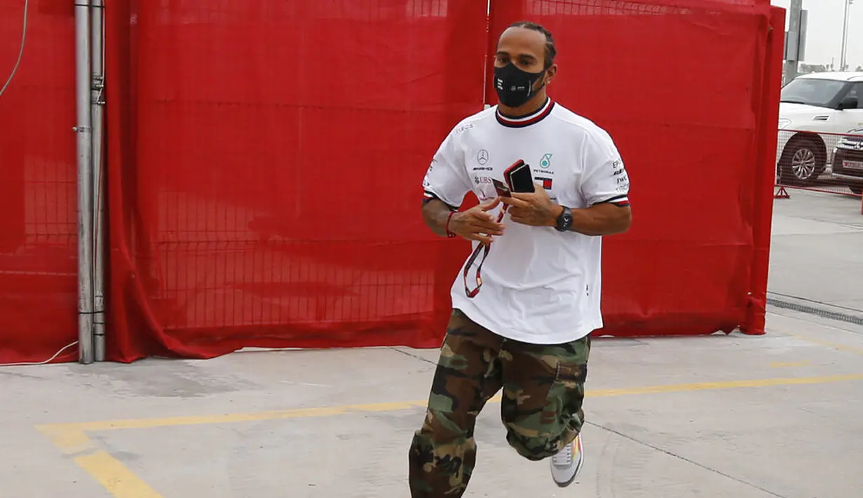Pembalap Mercedes Lewis Hamilton tiba di paddock pada latihan bebas pertama di Sirkuit Internasional Formula 1 Bahrain, Sakhir, Bahrain, Jumat (27/11/2020). Lewis Hamilton dinyatakan positif COVID-19. (Hamad Mohammed, Pool via AP, File)