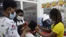 Penata rambut, memakai masker menata rambut pelanggan di dalam salon di Lagos, Nigeria, Rabu (26/5/2021). Salon tersebut menerapkan protokol kesehatan untuk para penata rambutnya saat melayani pelanggan untuk menghindari penyebaran virus Covid-19. (AP Photo/Sunday Alamba)
