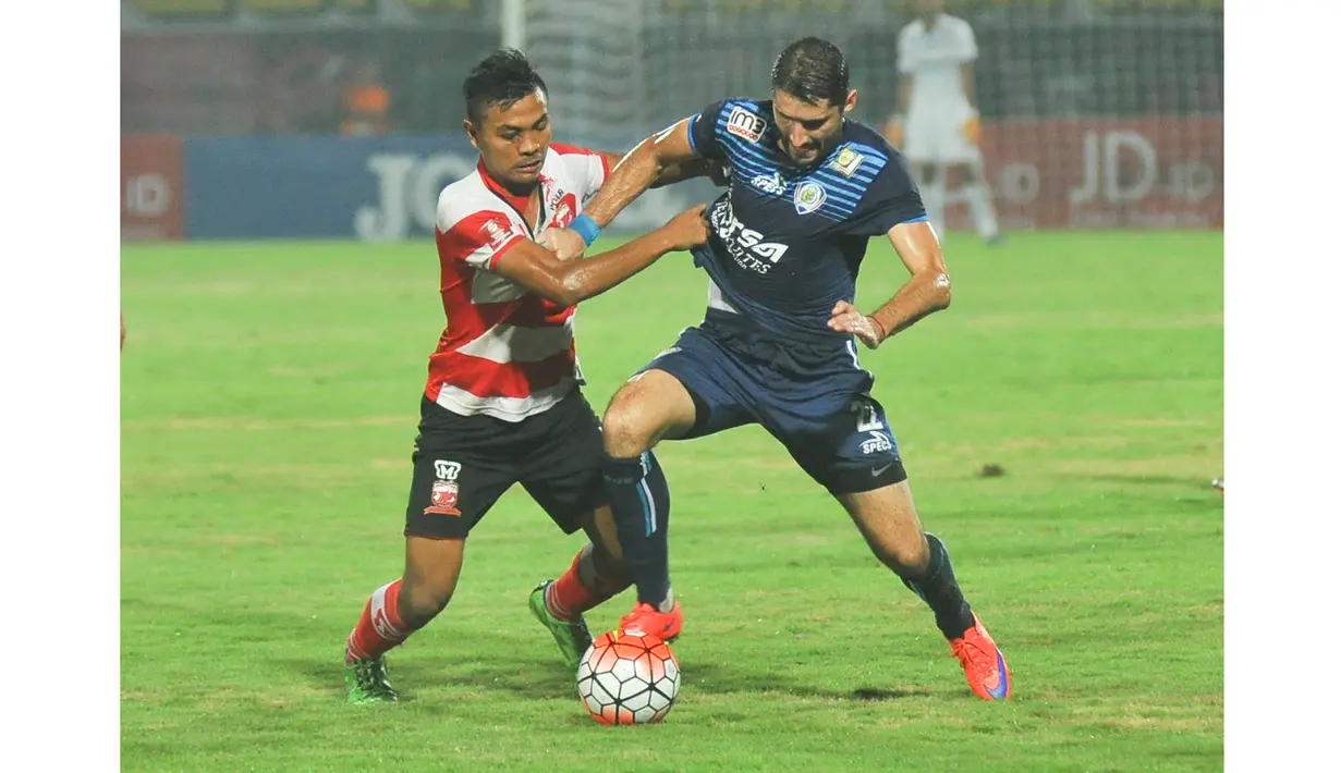 Pemain Arema Cronus, Srdan Lopicic (kanan) berusha keluar dari tekanan pemain Madura United, Asep Berlian pada laga Torabika Soccer Champions 2016 di Stadion Gelora Bangkalan, Jumat (6/5/2016) WIB. (Bola.com/Iwan Setiawan)