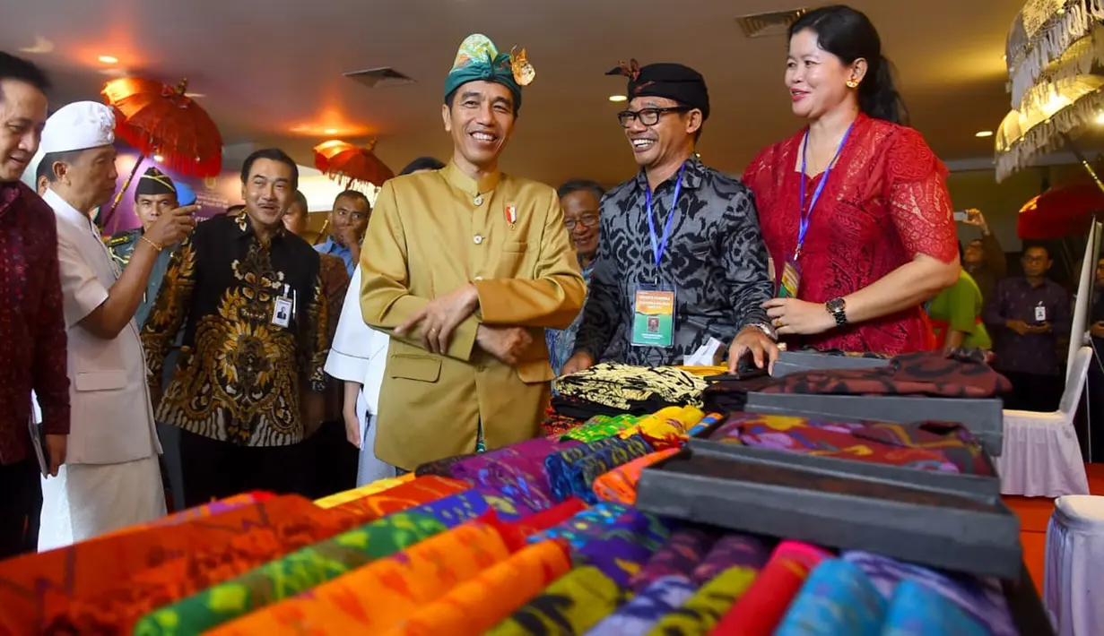 Presiden Joko Widodo (Jokowi) meninjau produk UMKM dalam kunjungan kerjanya di Sanur, Bali, Sabtu (23/6). Kunjungan kerja ini dalam rangka sosialisasi aturan baru terkait dengan Usaha Mikro Kecil dan Menengah (UMKM). (Liputan6.com/Pool/Biro Pers Setpres)