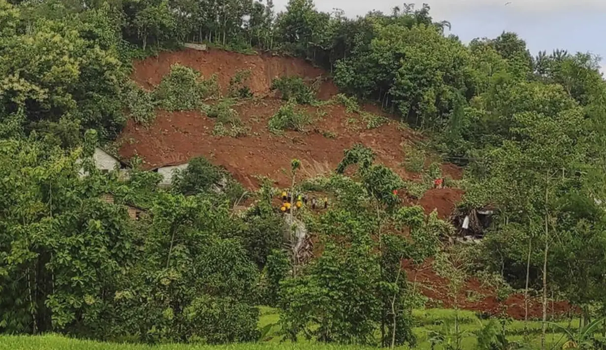 Penyelamat mencari korban di sebuah desa yang dilanda longsor di Nganjuk, Jawa Timur, Senin (15/2/2021). Tanah longsor mengakibatkan delapan unit rumah warga rusak berat. (Basarnas via AP)