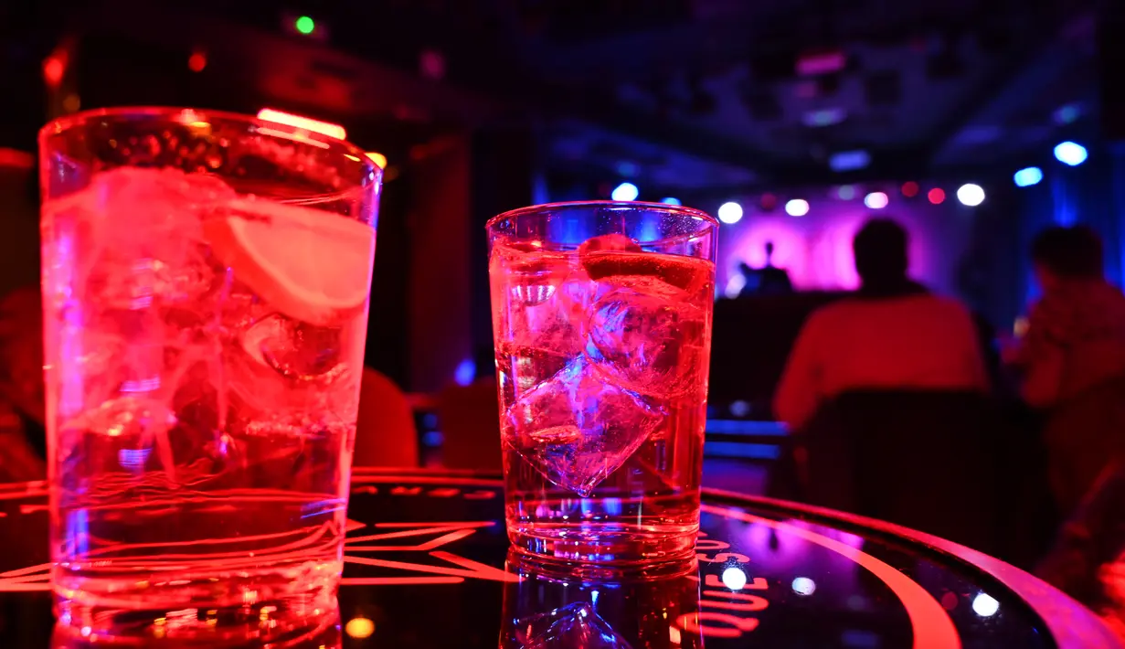 Dua minuman terlihat di atas meja saat seorang DJ tampil di Kafe Berlin di Madrid (17/1/2021). Dengan infeksi virus Corona harian mencapai rekor tertinggi setelah liburan Natal, beberapa wilayah Spanyol bergerak untuk semakin memperketat pembatasan pada kehidupan sosial. (AFP/Gabriel Bouys)