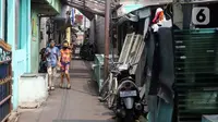 Dua anak berjalan di kawasan Intan Berduri, Sumur Batu, Jakarta, Rabu (9/06/2021). Kelurahan Sumur Batu memberlakukan mikro lockdown di RT 1, RT 2 dan RT di RW 03 setelah 34 warga positif COVID-19. (Liputan6.com/Herman Zakharia)