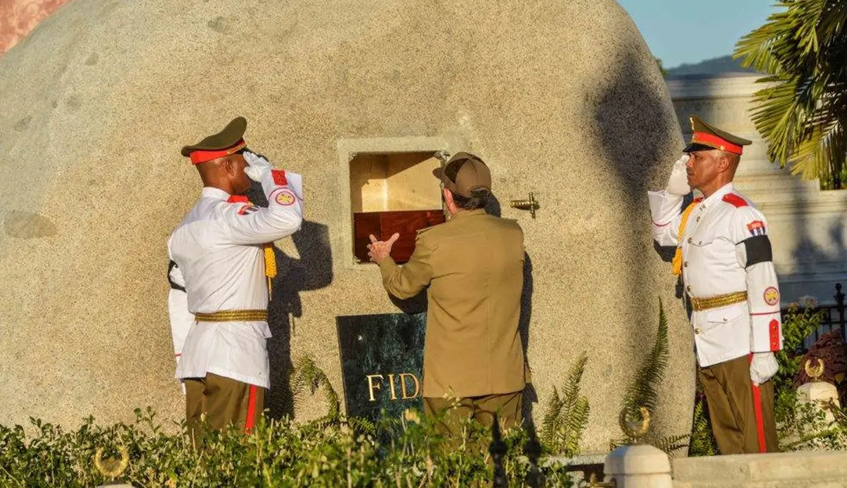 Presiden Kuba, Raul Castro meletakan kotak kayu berisi abu pemimpin Revolusi Kuba, Fidel Castro, ke dalam batu granit besar di pemakaman Santa Ifigenia, di Santiago, Kuba, (4/12). Fidel Castro meninggal pada usia 90 tahun. (REUTERS/ACN/Marcelino Vazquez)