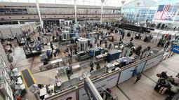 Wisatawan mengantre di gergang pemeriksaan Bandara Internasional Denver di Denver (26/12/2021). Maskapai menunda ratusan penerbangan pada Minggu (26/12), karena alasan keterbatasan petugas terkait Covid-19 menambah masalah perjalanan usai Natal. (AP Photo/David Zalubowski)