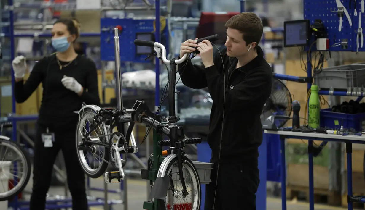 Para pekerja merakit sepeda lipat Brompton di pabrik Brompton di London, Inggris, 24 November 2020. Nasib industri sepeda Brompton semakin tidak menentu di tengah ketidakpastian Brexit, persaingan baru yang tak terduga dari China, dan pandemi COVID-19. (AP Photo/Matt Dunham)