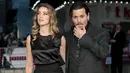 Johnny Depp (kanan) dan istri Amber Heard berpose saat menghadiri pemutaran perdana film "Black Mass " di London, Inggris, Minggu (11/10/2015). Johnny berperan sebagai James " Whitey " Bulger dalam film Black Mass. (REUTERS/Suzanne Plunkett)  