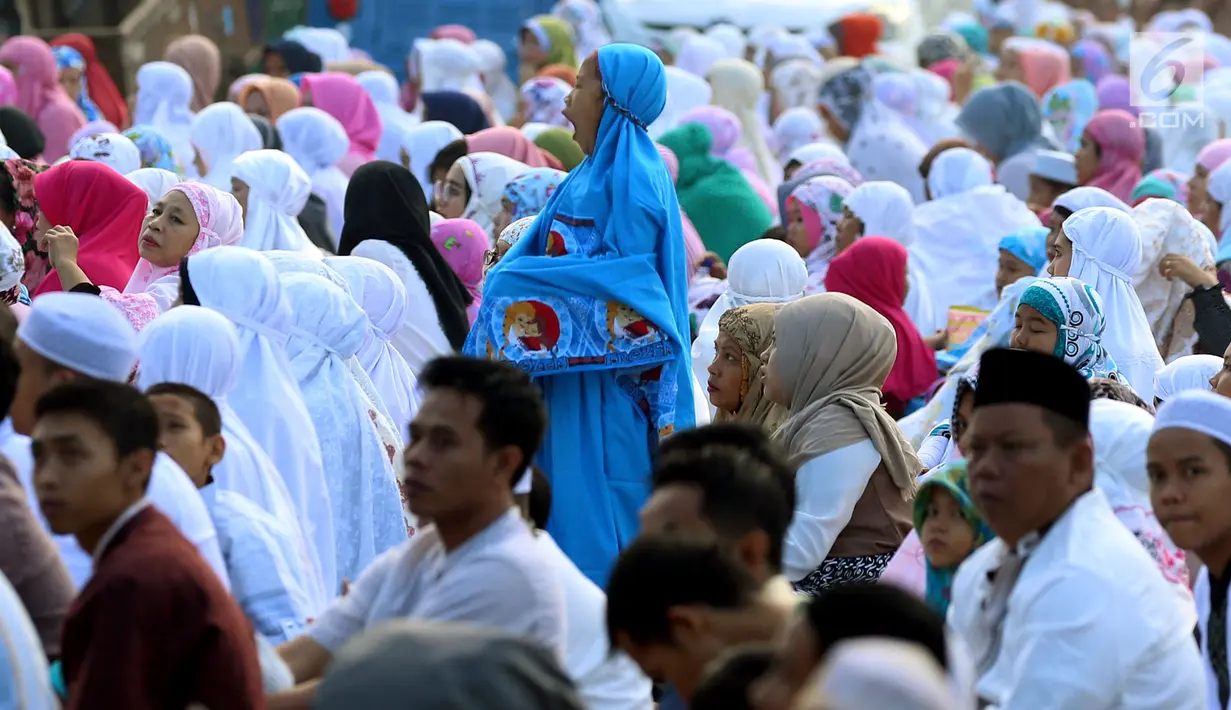 Seorang anak menguap saat Salat Idul Fitri di kawasan Senen, Minggu (25/6). Sebagian besar umat muslim merayakan Idul Fitri 1438 H pada Minggu (25/6) berdasarkan ketetapan pemerintah tentang 1 Syawal melalui sidang Isbat. (Liputan6.com/Johan Tallo)