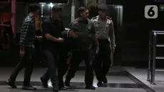 Petugas Komisi Pemberantasan Korupsi (KPK) menggiring orang yang mengaku-aku sebagai pegawai KPK di Gedung Merah Putih KPK, Jakarta, Rabu (5/2/2025). (Liputan6.com/Helmi Fithriansyah)