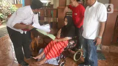 Petugas dari Kantor Pertanahan Kota Administrasi Jakarta Selatan menyerahkan sertifikat tanah kepada warga Jati Padang yang sedang sakit, Jakarta, Selasa (31/1). Pemerintah melalui Kementerian ATR/BPN meluncurkan Program Prioritas Nasional berupa Percepatan Pendaftaran Tanah Sistematis Lengkap (PTSL) untuk menjamin kepastian dan perlindungan hukum atas kepemilikan tanah masyarakat. (merdeka.com/Arie Basuki)