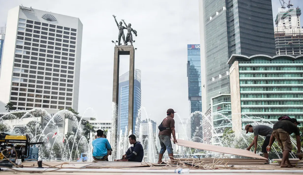 Sejumlah pekerja menyelesaikan pembuatan panggung HUT ke-492 DKI di area Bundaran HI, Jakarta, Kamis (20/6/2019). Panggung megah tersebut nantinya akan digunakan sebagai area pesta rakyat. (Liputan6.com/Faizal Fanani)