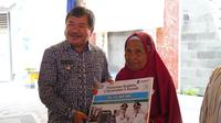Bupati Garut Rudy Gunawan memberikan simbolis pemberikan bantuan program rutilahu bagi salah seorang warga penerima dari 442 desa dan kelurahan di Garut. (Liputan6.com/Jayadi Supriadin)