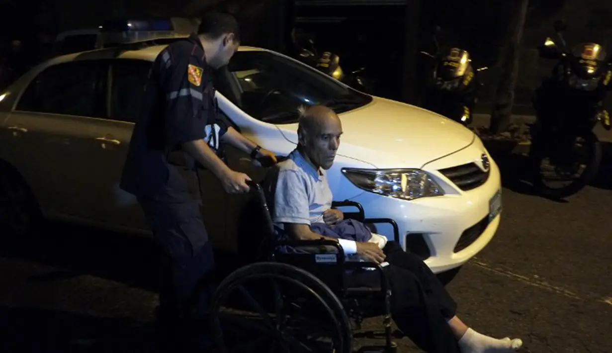 Petugas medis membantu salah satu lanjut usia (lansia) yang menjadi korban kebakaran sebuah panti jompo swasta di Caracas, Venezuela, Minggu (23/8/2015) waktu setempat. Delapan orang penghuni panti tewas dalam peristiwa tersebut. (AFP PHOTO/JUAN BARRETO)