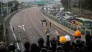 Demonstran prodemokrasi bersorak di jembatan ketika mereka memblokir jalan di luar Chinese University, Hong Kong, Rabu (13/11/2019). Gerakan antipemerintah Hong Kong yang telah berlangsung selama lima bulan bertindak semakin keras. (AP Photo/Kin Cheung)