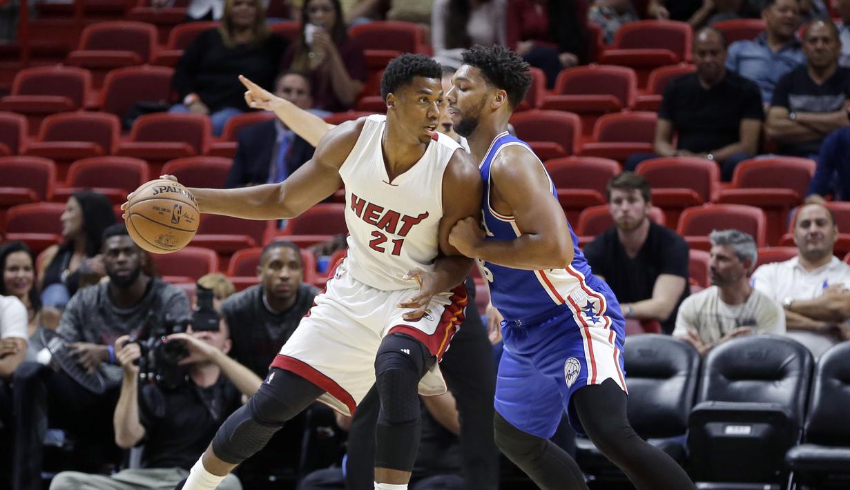 Miami Heat center, Hassan Whiteside #21 menggiring bola saat berhadapan dengan pemain  Philadelphia 76ers,  Jahlil Okafor (kanan)  pada laga NBA preseason basketball game di Miami, Sabtu (22/10/2016) WIB. (AP/Alan Diaz)
