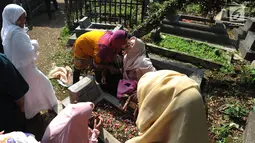 Sejumlah warga melakukan ziarah kubur di TPU Dreded  Bogor (15/6). Hari Raya Idul Fitri 1439 H dimanfaatkan warga untuk melakukan ziarah kubur bagi keluarga dan kerabat yang sudah meninggal. (Merdeka.com/Arie Basuki)