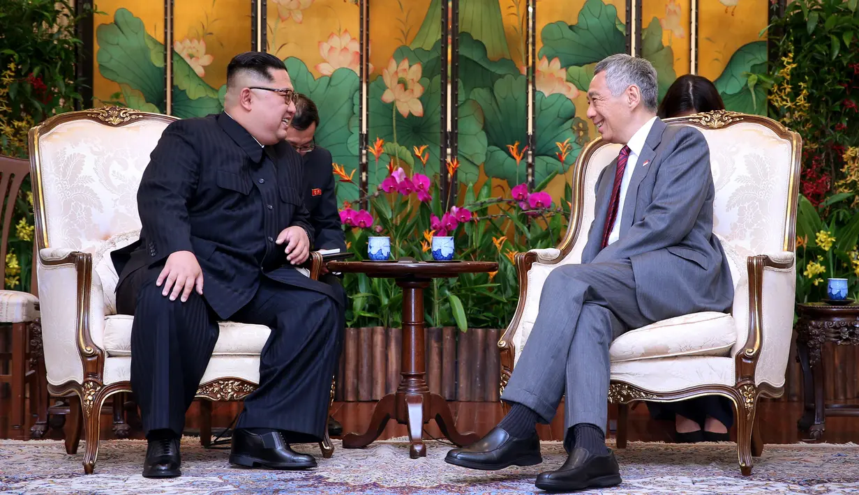 Pemimpin Korea Utara, Kim Jong-un berbincang dengan Perdana Menteri Singapura Lee Hsien Loong di Istana Kepresidenan Singapura, Minggu (10/6). Kim Jong-un dan Donald Trump akan bertemu 12 Juni. (AFP Photo/HO/Kementerian Kominfo Singapura)