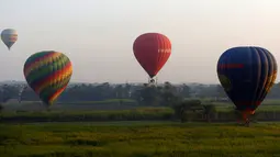 Sejumlah balon udara panas yang membawa wisatawan mengudara di atas kota Luxor, Kairo, Mesir (13/12). Kota Luxor dijuluki sebagai "The World Greatest Open Air Museum". (Reuters/Amr Abdallah Dalsh)