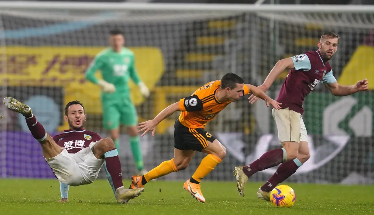 Gelandang Wolverhampton Wanderers, Daniel Podence (tengah), lolos dari hadangan gelandang Burnley, Dwight Mcneill (kiri), dalam laga lanjutan Liga Inggris pekan ke-14 di Turf Moor Stadium, Senin (21/12/2020). Wolverhampton kalah 1-2 dari Burnley. (AFP/Jon Super/Pool)