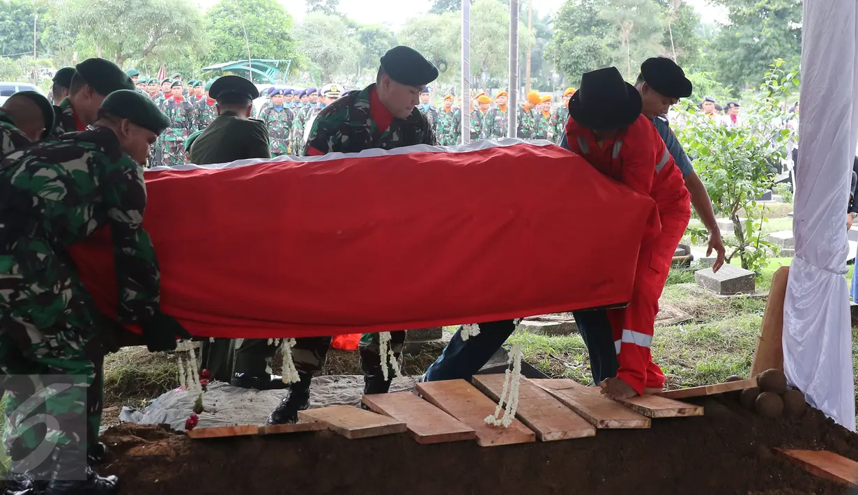 Sejumlah personel TNI menurunkan peti jenazah Zumarnis Zein, ayah artis Marini Zumarnis ke liang lahat di TPU Karet Bivak, Jakarta, Jumat (17/6). Prosesi pemakaman dilakukan secara militer, diiringi bunyi tembakan. (Liputan6.com/Herman Zakharia)