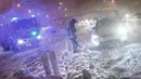 Petugas pemadam kebakaran membantu pengemudi mobil yang terjebak salju tebal di Jalan Lingkar M30, Madrid, Spanyol, Jumat (8/1/2021). Salju tebal memotong dua jalan lingkar di Madrid, M30 dan M40. (OSCAR DEL POZO/AFP)