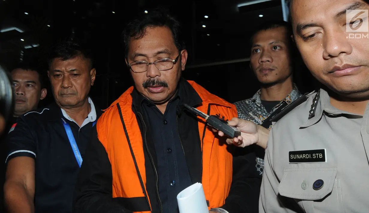 Gubernur Kepri Nurdin Basirun dikawal petugas usai menjalani pemeriksaan 1 x 24 jam di Gedung KPK, Jakarta, Jumat dini hari (12/7/2019). Nurdin Basirun resmi ditahan KPK bersama tiga tersangka terkait suap izin lokasi rencana reklamasi di wilayah Kepri. (merdeka.com/Dwi Narwoko)