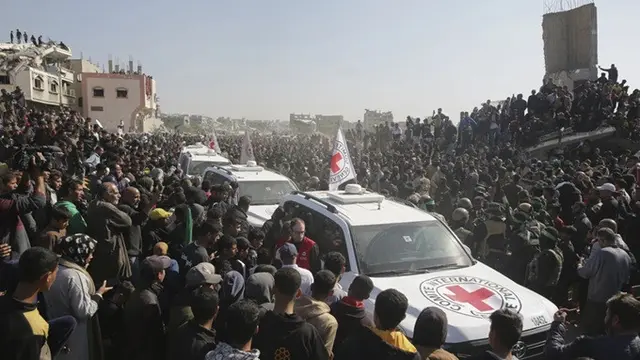 Kerumunan orang mengelilingi mobil Palang Merah saat mereka tiba di lokasi penyerahan sandera oleh Hamas di Khan Younis, Gaza Selatan, Kamis (30/1/2025).