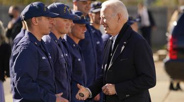 Presiden Joe Biden dengan anggota penjaga pantai di Stasiun Penjaga Pantai Amerika Serikat Brant Point di Nantucket, Massachuset, Kamis, 25 November 2021. (AP Photo/Carolyn Kaster)