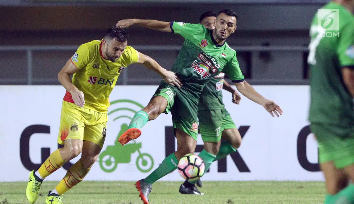 Pemain anyar PS TNI, Redouane Zerzori (tengah) berebut bola dengan pemain Bhayangkara FC, Ilija Spasojevic saat lanjutan Liga 1 Indonesia di Stadion Pakansari, Kab Bogor, Minggu (3/9). PS TNI kalah 0-1. (Liputan6.com/Helmi Fithriansyah)