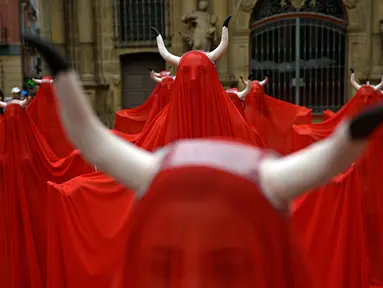 Orang-orang menutup diri dengan kain warna merah saat memprotes kekejaman terhadap hewan sebelum dimulainya Festival San Fermin di Alun-Alun Plaza del Ayuntamiento, Pamplona, Spanyol, Rabu (5/7/2023). (AP Photo/Alvaro Barrientos)