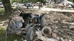 Sebuah traktor duduk di antara puing-puing di Waverly, Tennessee, Rabu (25/8/2021). Hujan deras selama akhir pekan menyebabkan banjir di Tennessee Tengah dan telah mengakibatkan puluhan orang tewas karena rumah dan jalan pedesaan hanyut. (AP Photo/Mark Humphrey)