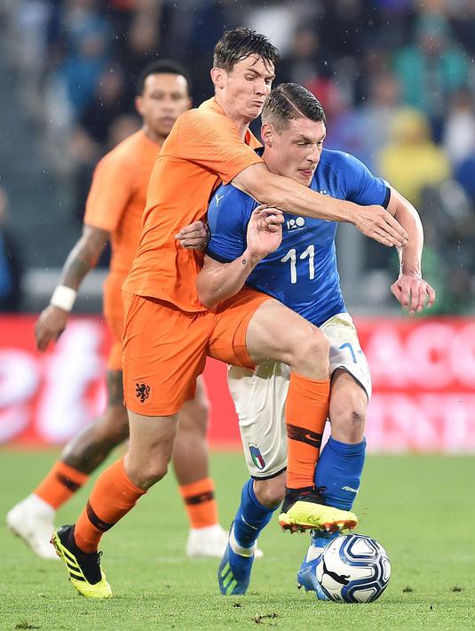 Pemain Italia, Andrea Belotti (depan) berusaha keluar dari tekanan pemain Belanda, Marten De Roon pada laga uji coba di Allianz Stadium, Turin, (4/6/2018). Italia dan Belanda bermain imbang 1-1. (Alessandro Di Marco/ANSA via AP)