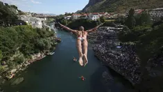 Seorang penyelam melompat dari Jembatan Tua selama kompetisi menyelam dari ketinggian ke-456 di Mostar, Bosnia, Minggu (31/7/2022). Sebanyak 31 penyelam dari Bosnia dan beberapa wilayah melompat dari jembatan setinggi 23 meter ke Sungai Neretva. (AP Photo/Armin Durgut)