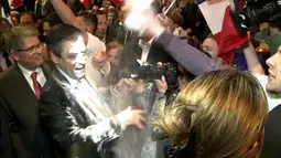 Kandidat Presiden Prancis, Francois Fillon bereaksi ketika seseorang melemparkan tepung ke arahnya pada sebuah acara kampanye di Prancis Timur, Kamis (6/4). Seorang pria meneriakkan kata ‘Lobbyist!’ sebelum melempar tepung padanya. (JULIEN SENGEL/AFP)